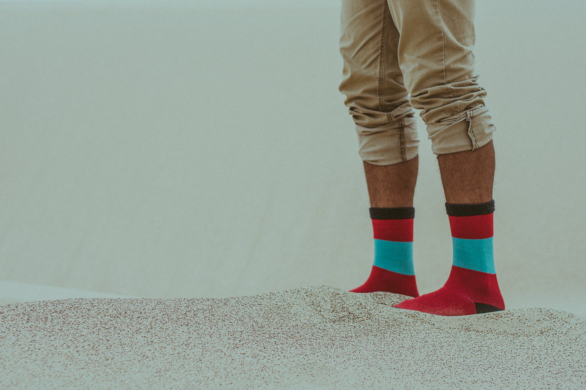 Person Wearing Red Socks Standing on Sand