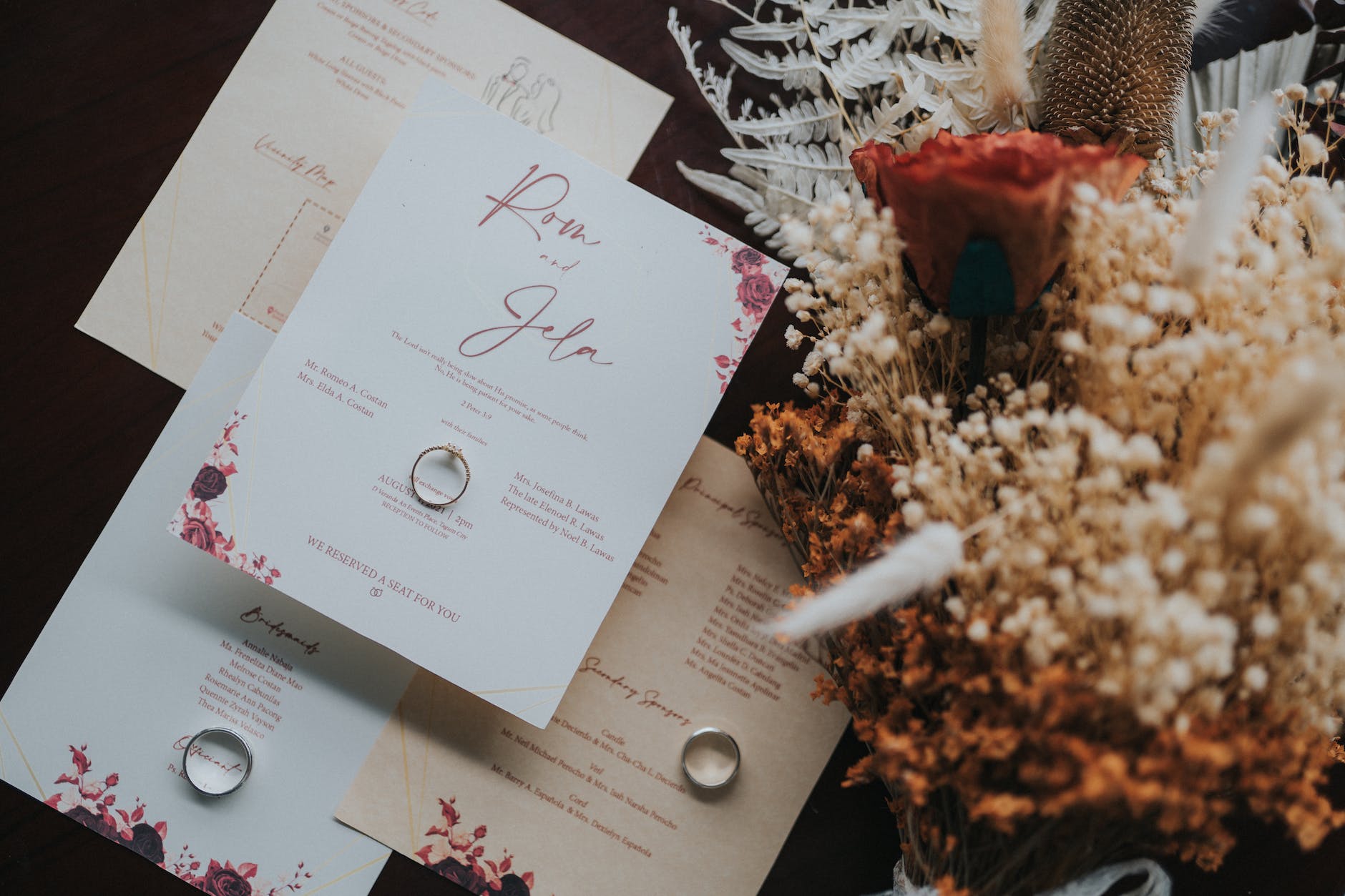 wedding invites lying on table next to bouq