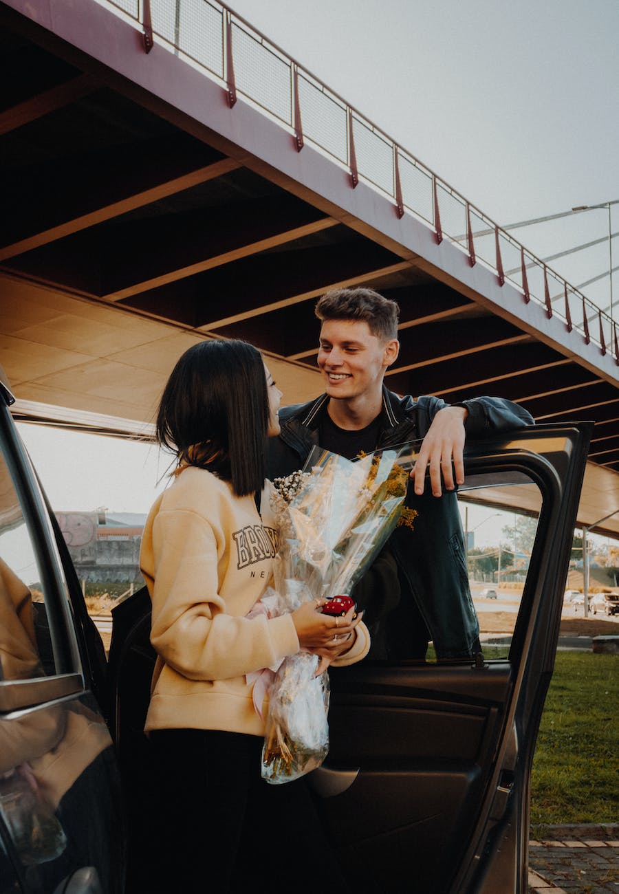 woman holding flowers and looking at her boyfriend