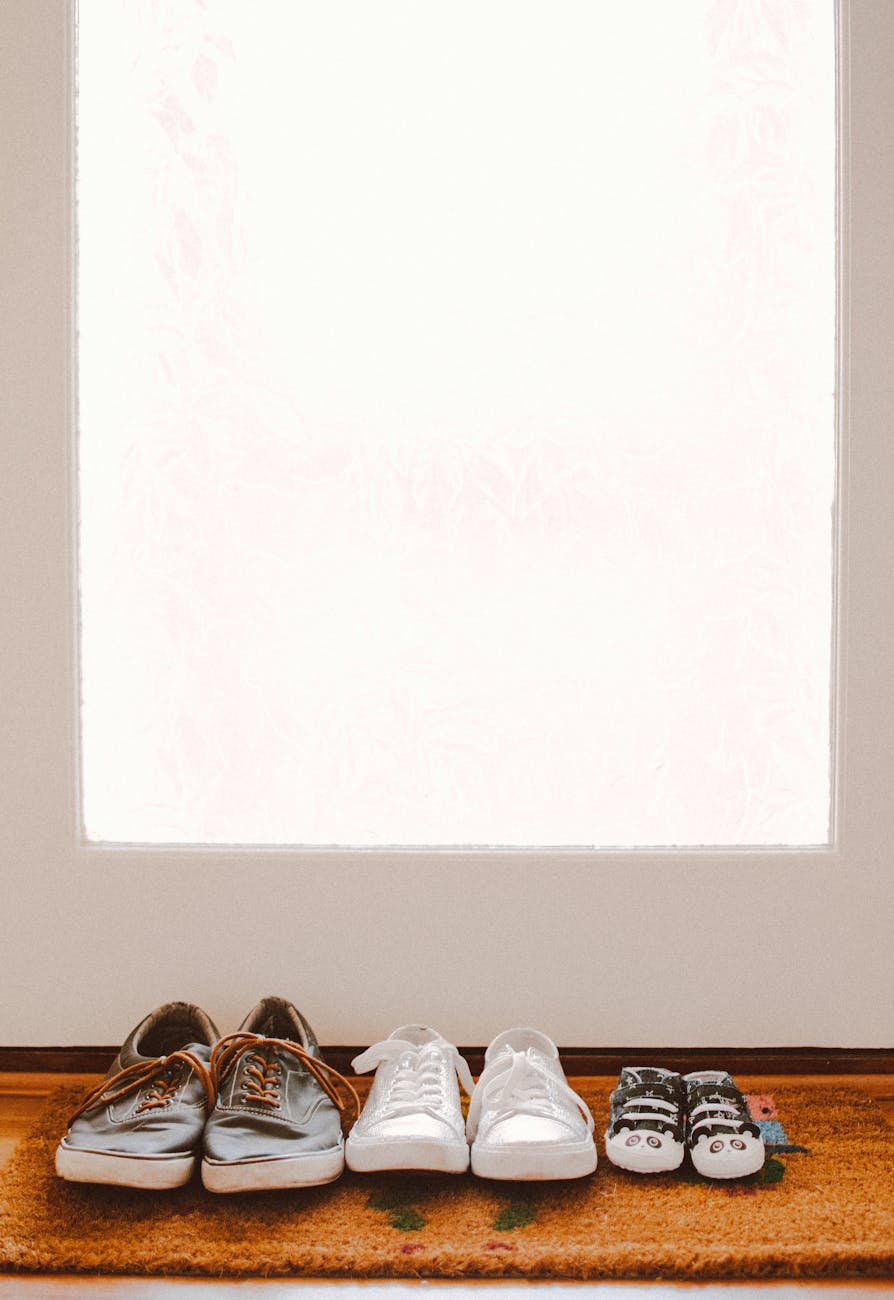 three pairs of shoes on brown rug