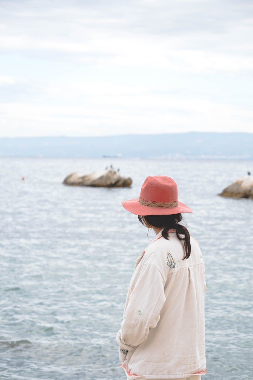 woman wearing pink hat by the sea