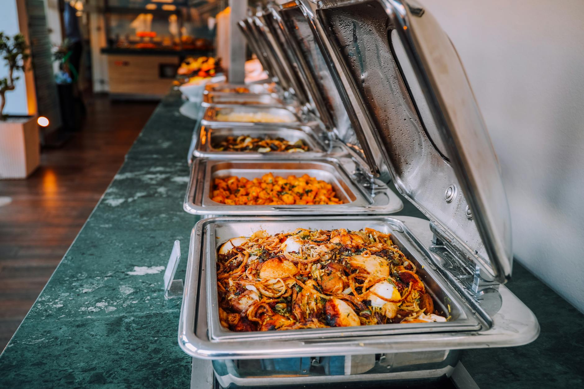 assorted cooked foods inside food warmers