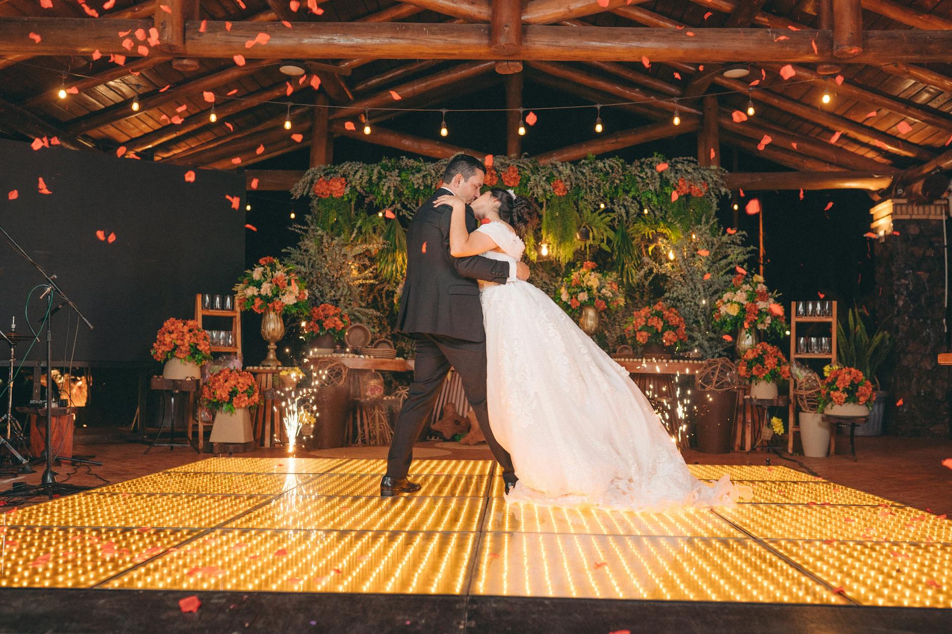 a bride and groom dance on a dance floor with flowers