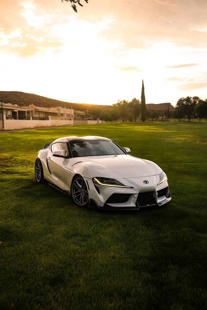sleek white sports car at sunset on green lawn