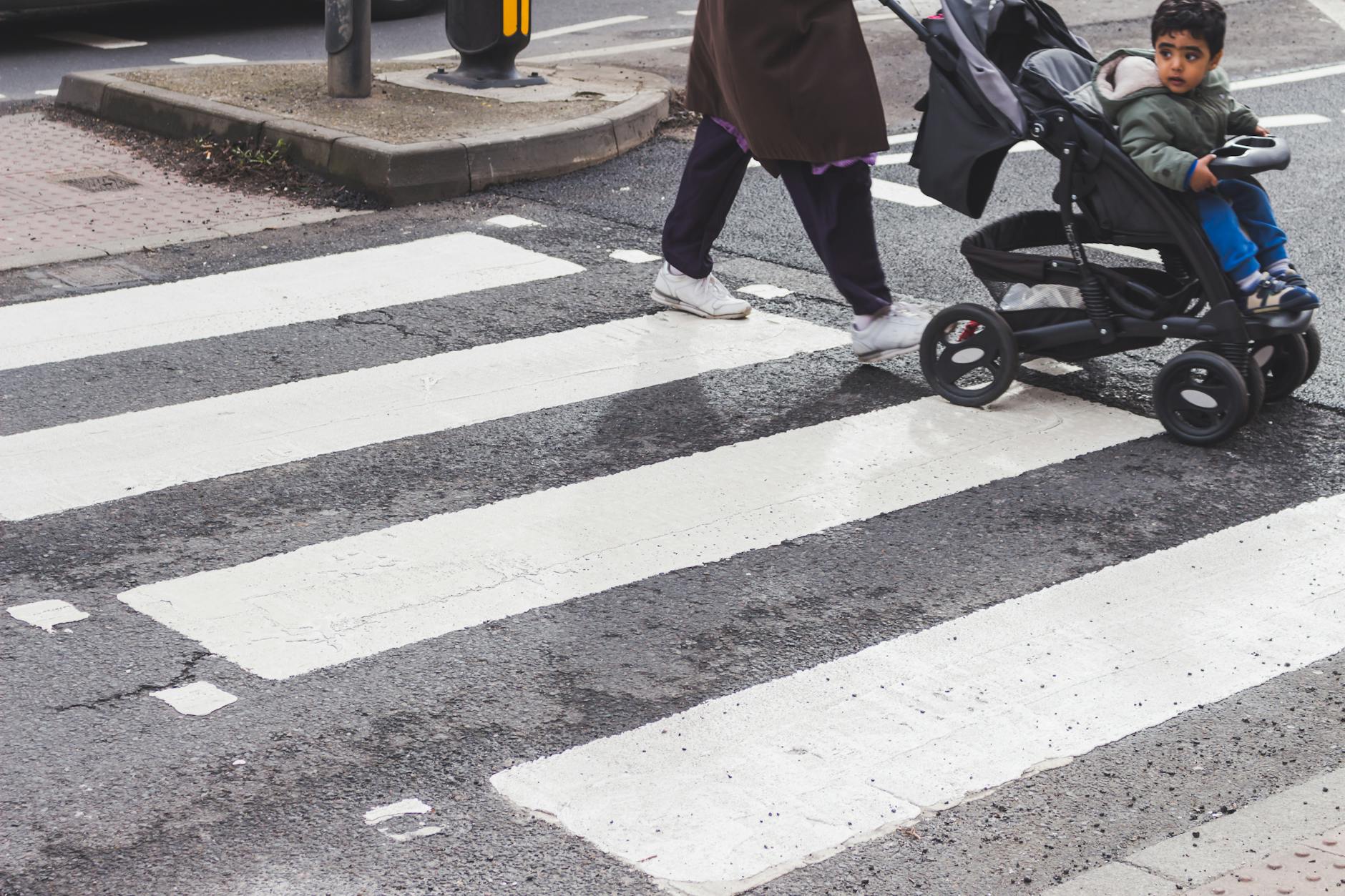 person pushing stroller crosswalk on pedestrian lane