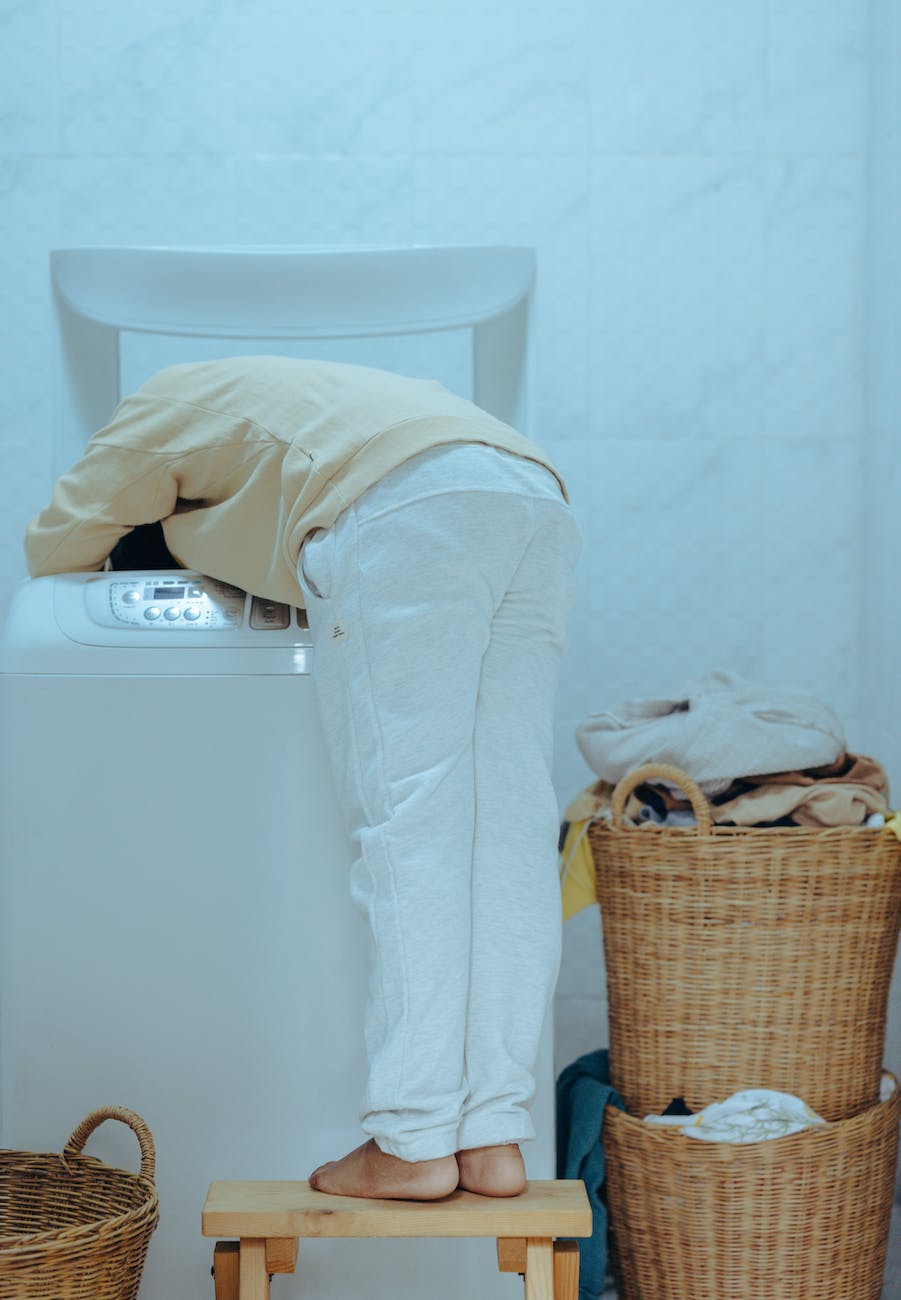 funny little kid taking out clothes from washing machine