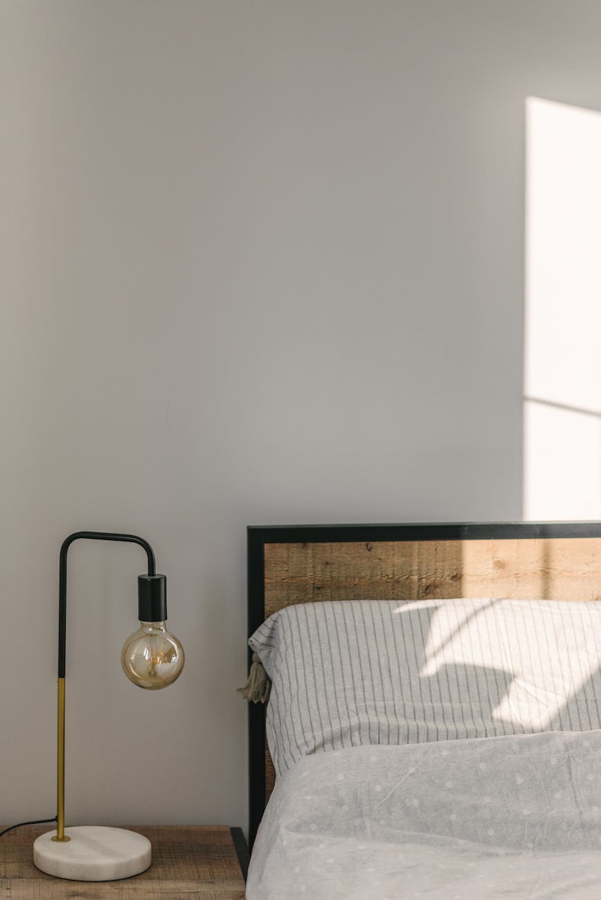 bedroom interior with lamp near wall in sunlight