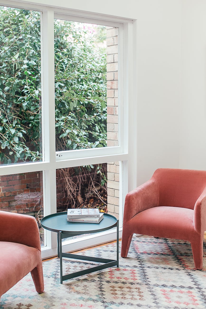 cozy armchair with small table placed near window in house