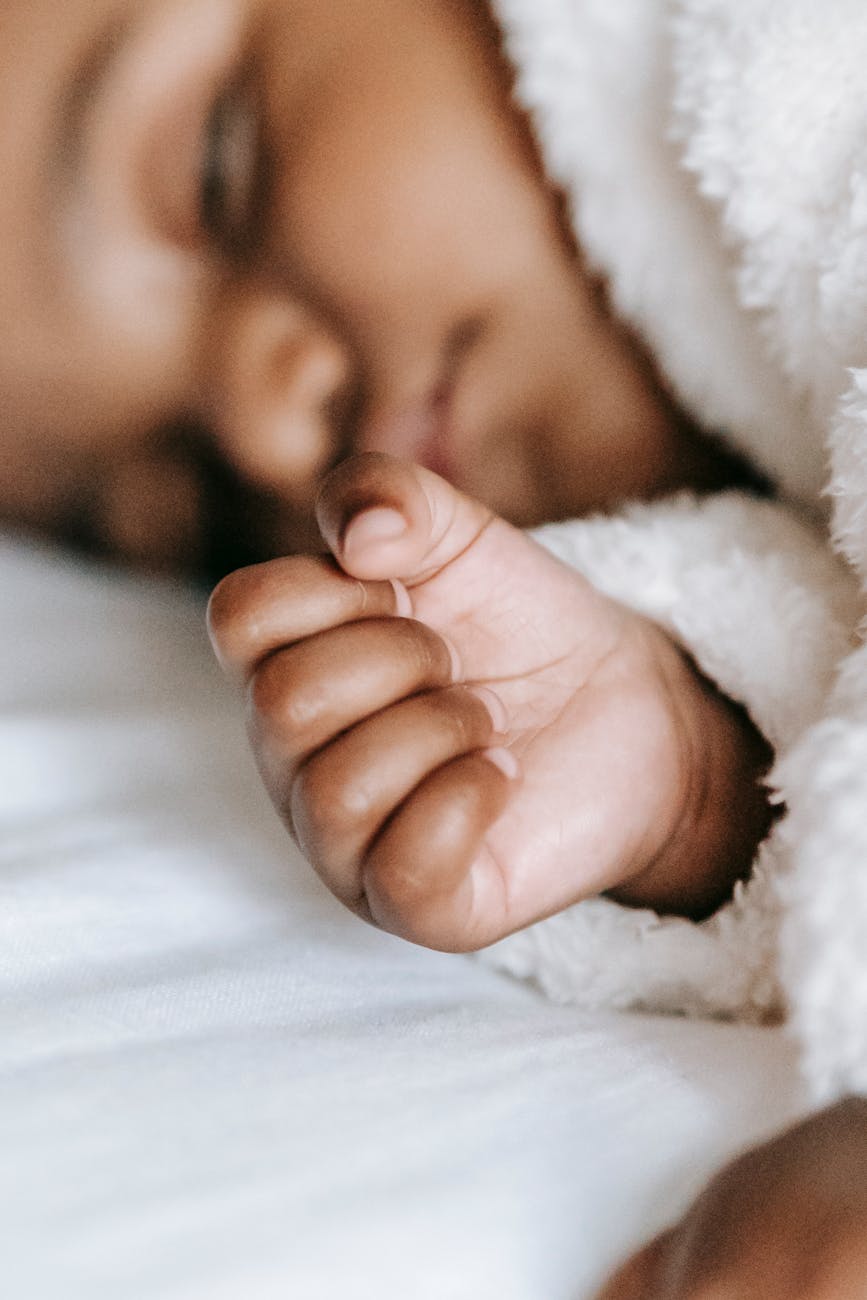 cute black newborn baby sleeping on soft bed