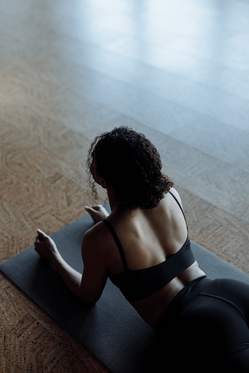 woman in black sports bra lying on floor