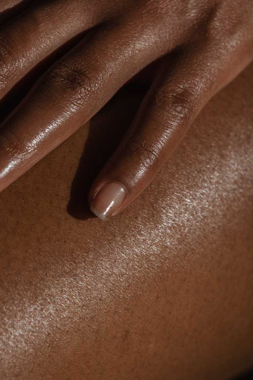 crop ethnic person touching bare skin