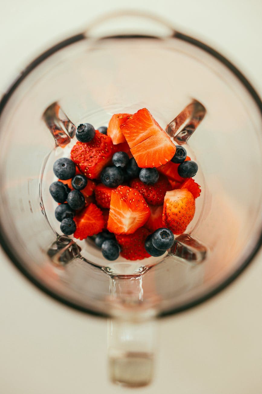 overhead shot of blueberries and strawberries in a blender