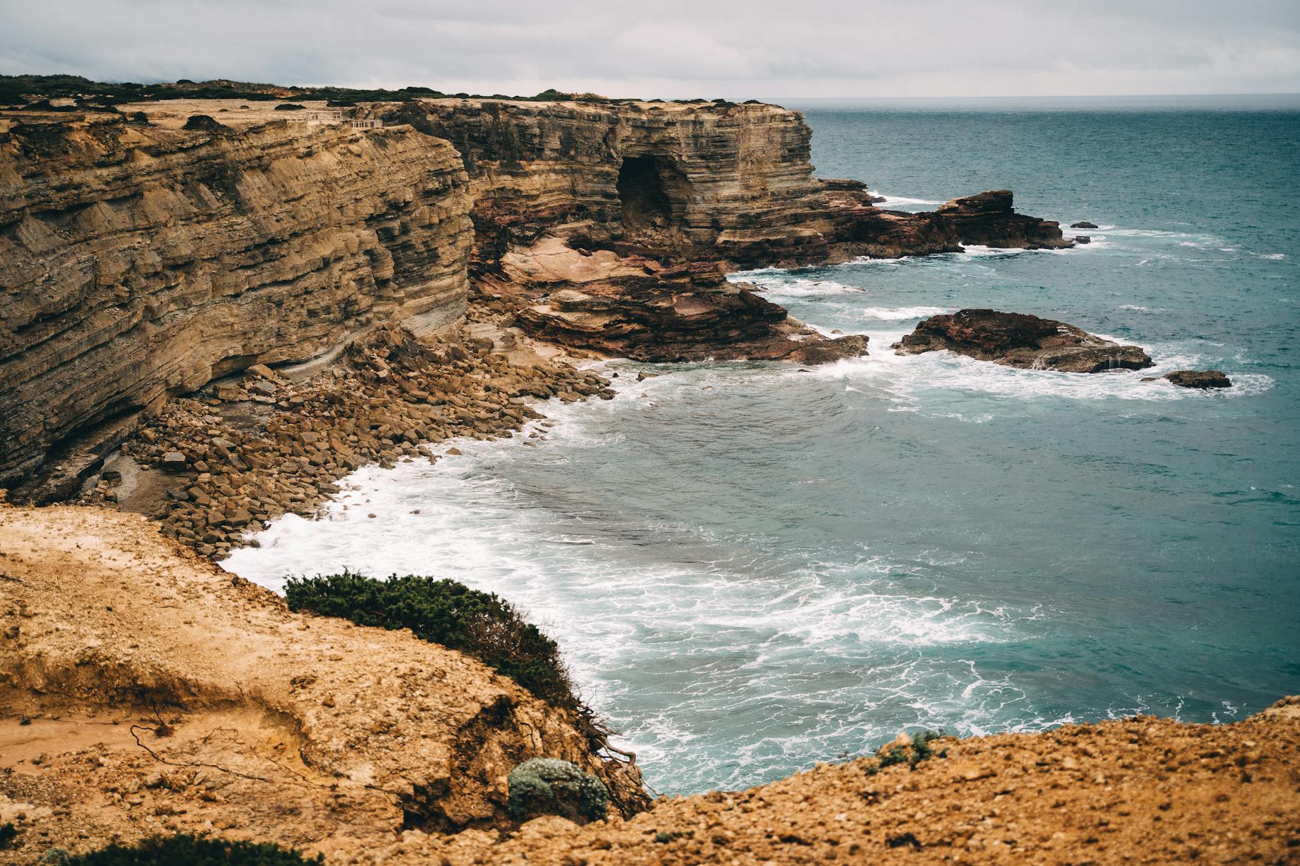 aerial view of ocean crashing on the rocks