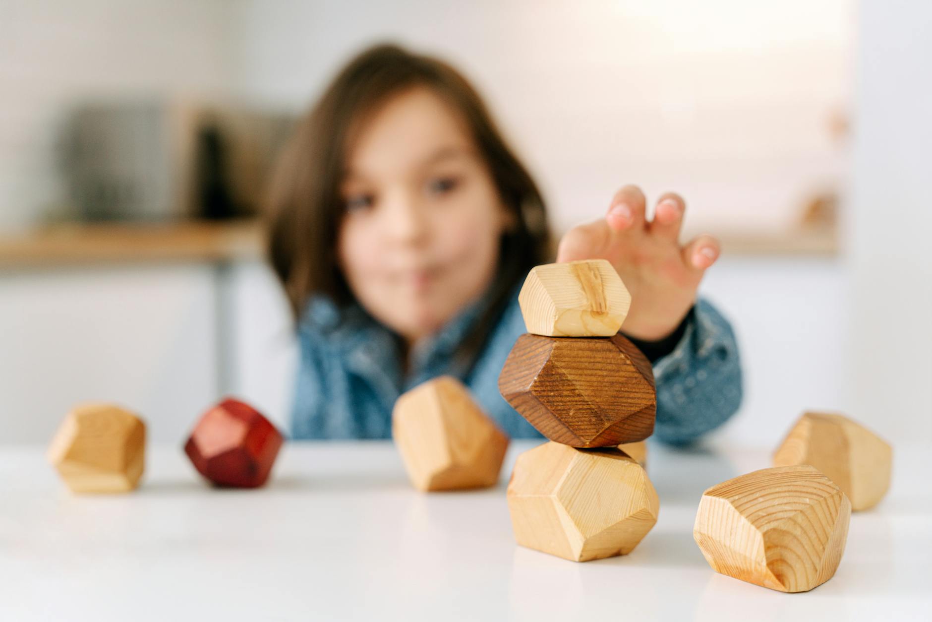 shallow focus photo of a kid playing wooden blocks